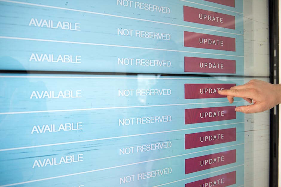 A person with a light skin tone uses their index finger to press an 'UPDATE' button on a large digital screen displaying a schedule of gardening services. The screen shows several rows with the word '